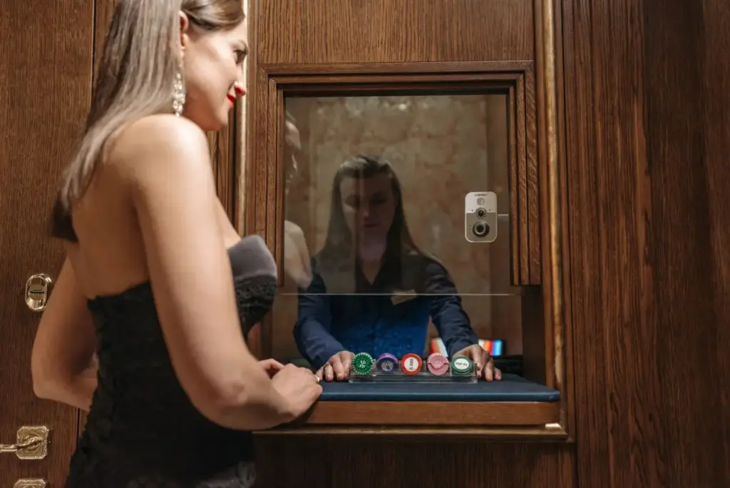 Uma mulher em um balcão de cassino recebendo fichas de um caixa, destacando glamour e jogos de azar.