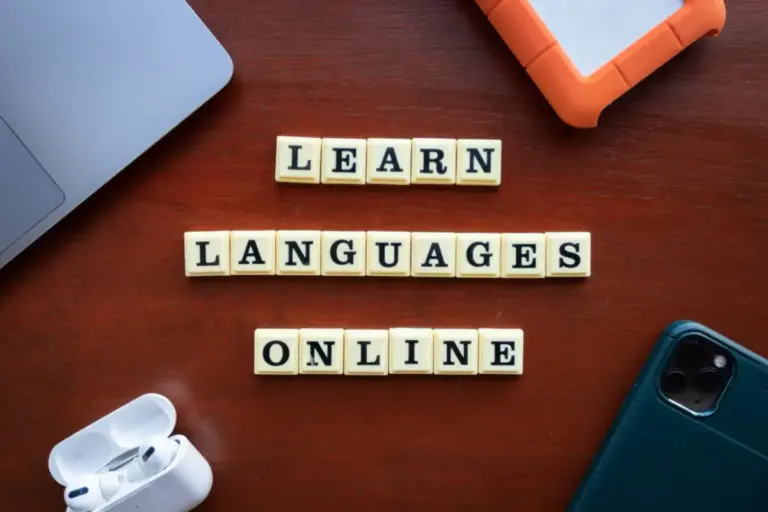 Composição vista de cima de ferramentas de aprendizado de idiomas com dispositivos e blocos de texto sobre a mesa.
