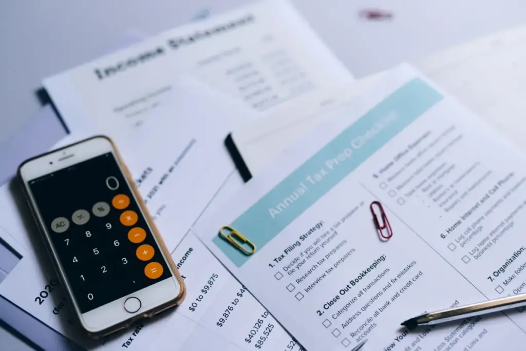 Preparação de impostos com documentos, calculadora no smartphone e checklist.