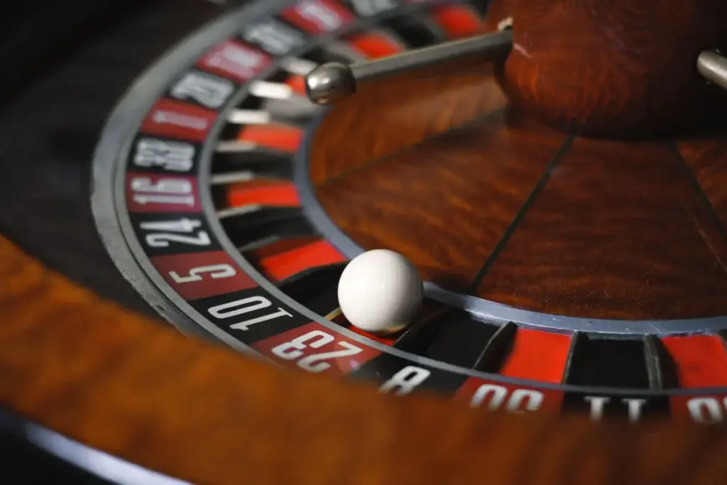Imagem detalhada em close-up de uma roleta destacando números e a bola girando em um ambiente de cassino.
