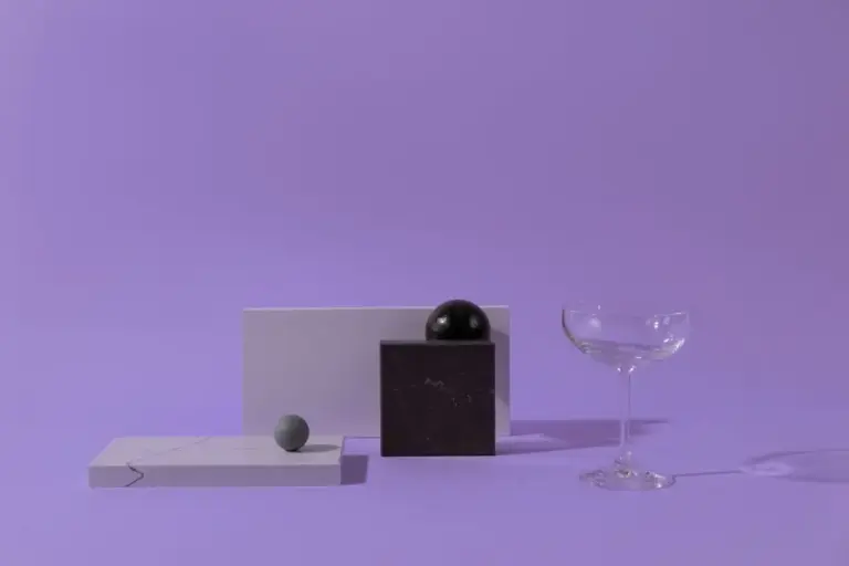 Composição minimalista abstrata de formas geométricas e um copo, sobre um fundo pastel.