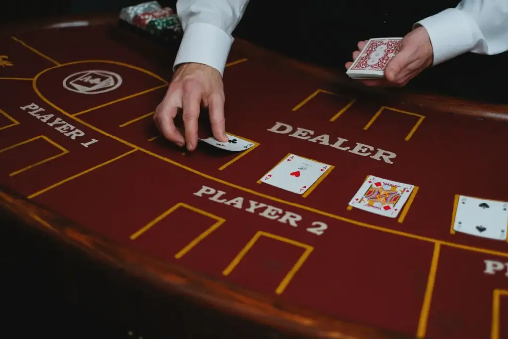 Um crupiê de cassino distribui cartas de baralho em uma mesa de pôquer, pronto para um jogo.