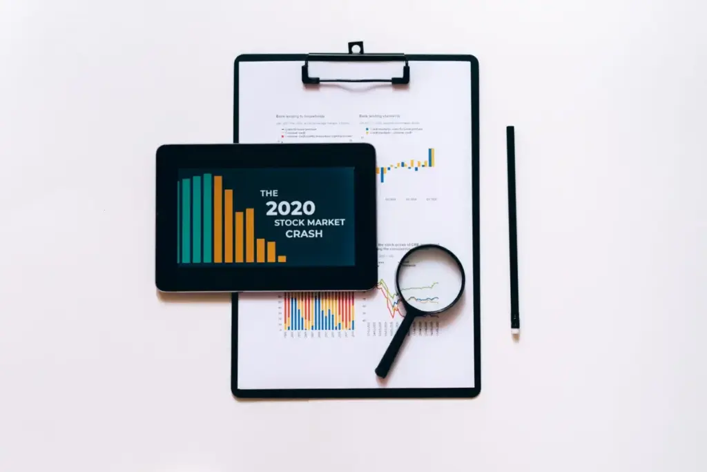 Tablet, lupa e prancheta para análise do mercado de ações.