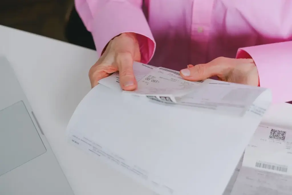 Empresário lidando com recibos de papel, meticulosamente organizados.